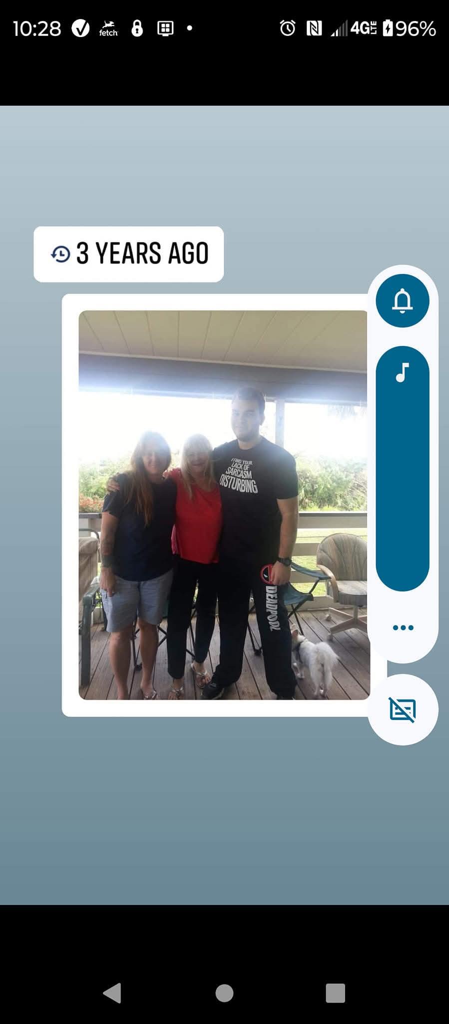 Three friends pose together on a balcony, radiating happiness and companionship during a sunny day.