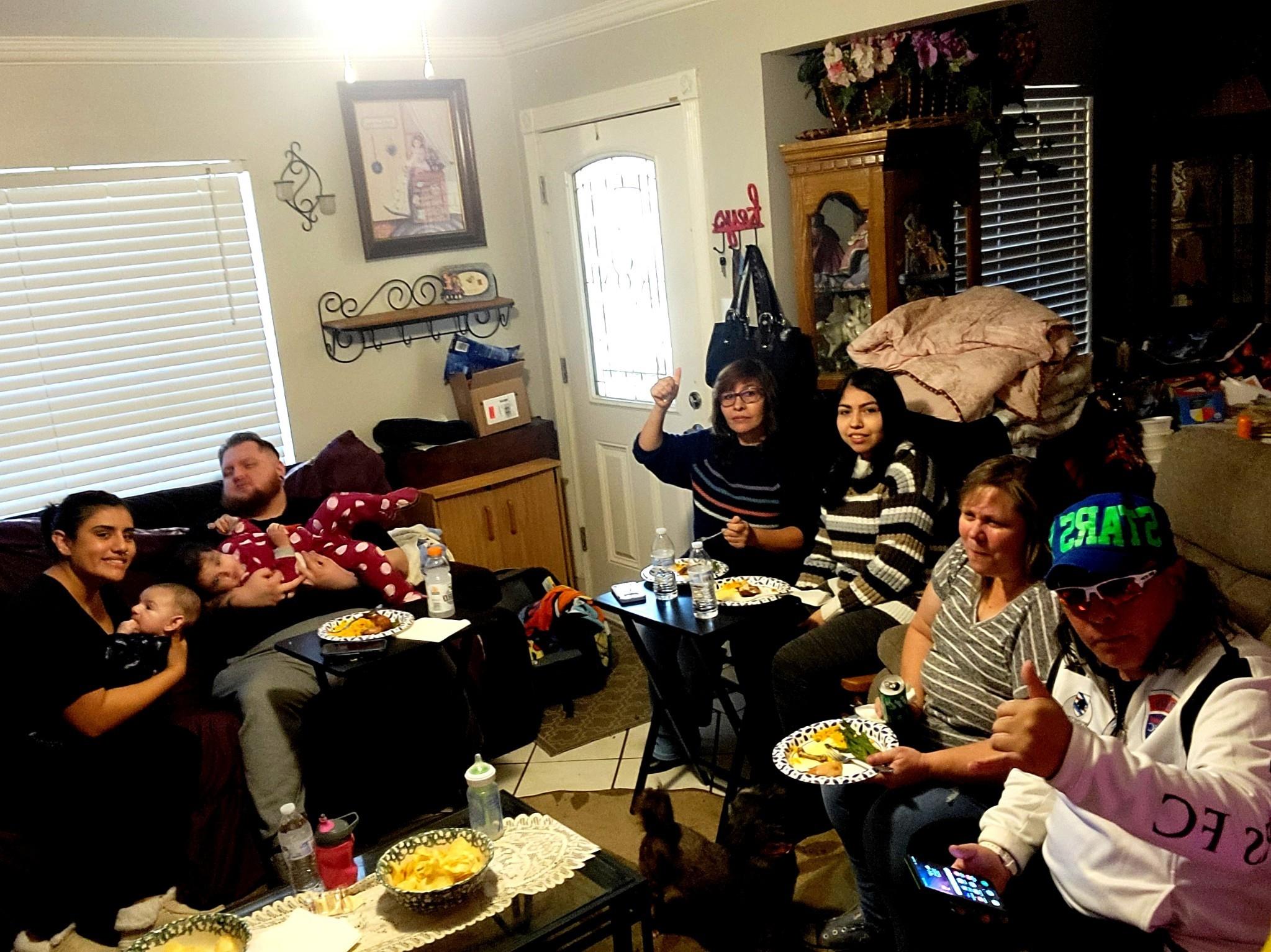 Friends and family gather in a warm living room to share laughter and a delicious meal together.