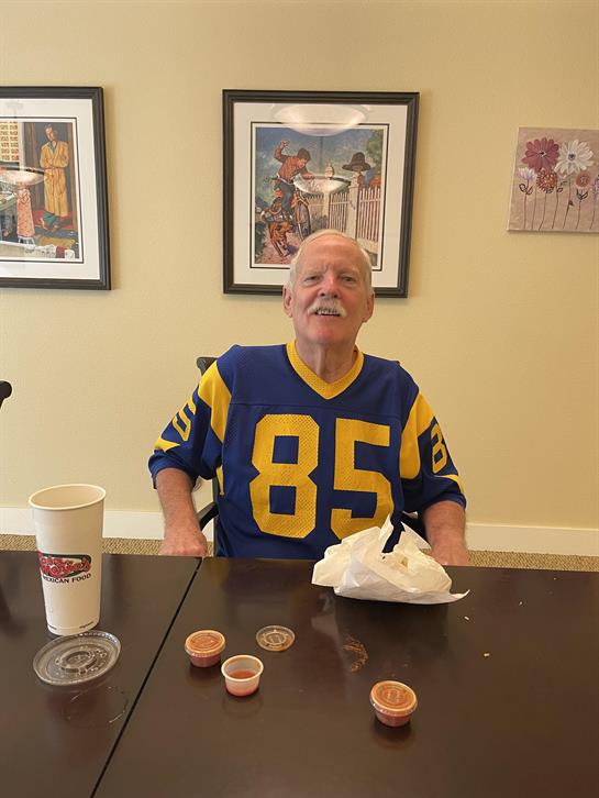 A man sitting at a table with a cup and a sauce