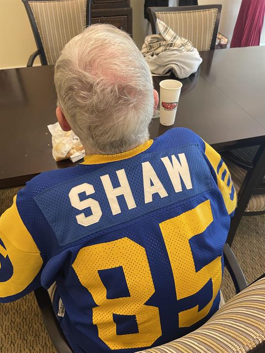 A man in a jersey sitting at a table