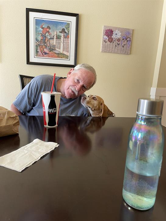 A man and dog sitting at a table