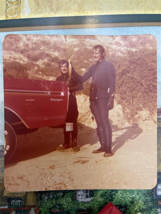 A man and woman standing next to a red truck