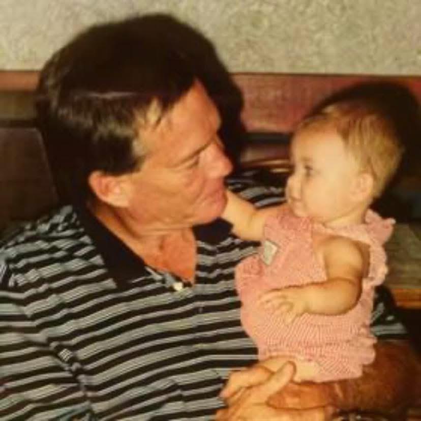 A man joyfully interacts with a baby, sharing a tender moment in a cozy indoor environment.