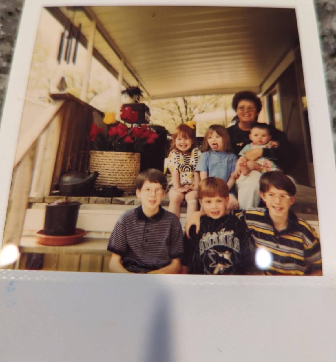 A joyful gathering of family and friends on porch steps, sharing smiles and laughter.