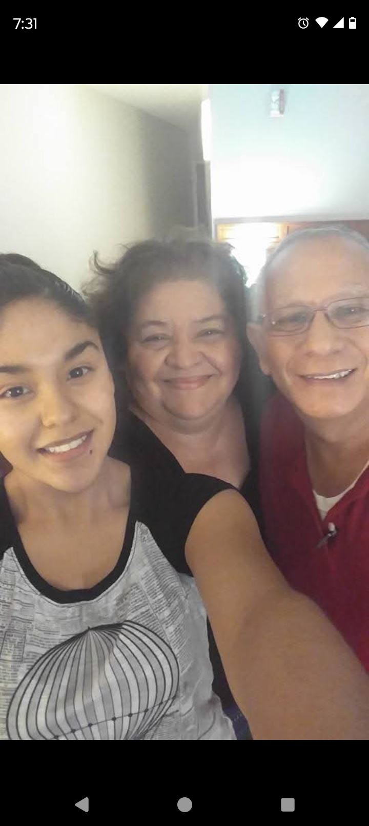 Three family members share a happy moment together, smiling warmly in a cozy setting.