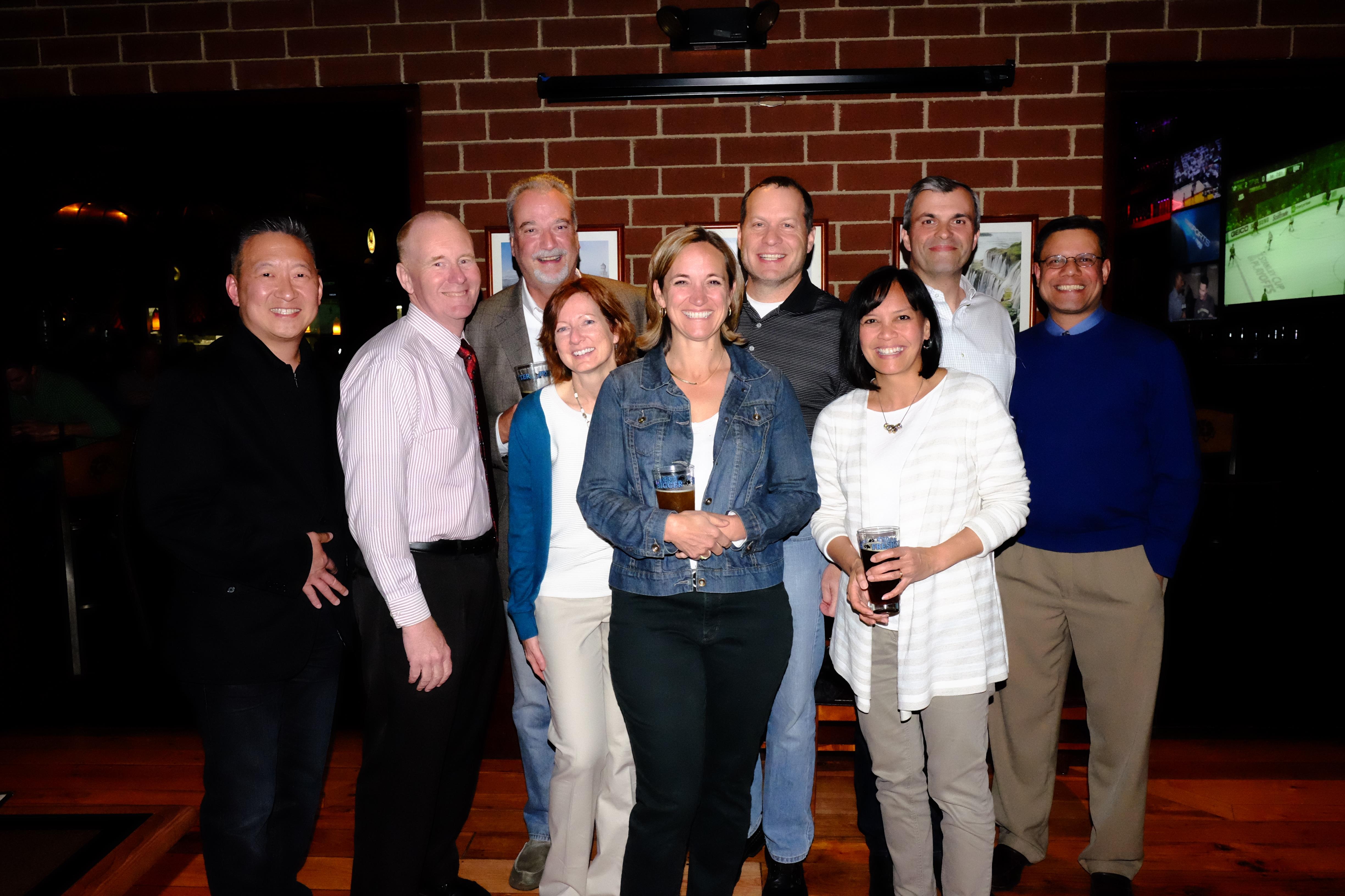 People are enjoying a festive atmosphere, sharing smiles and drinks in a warm pub.