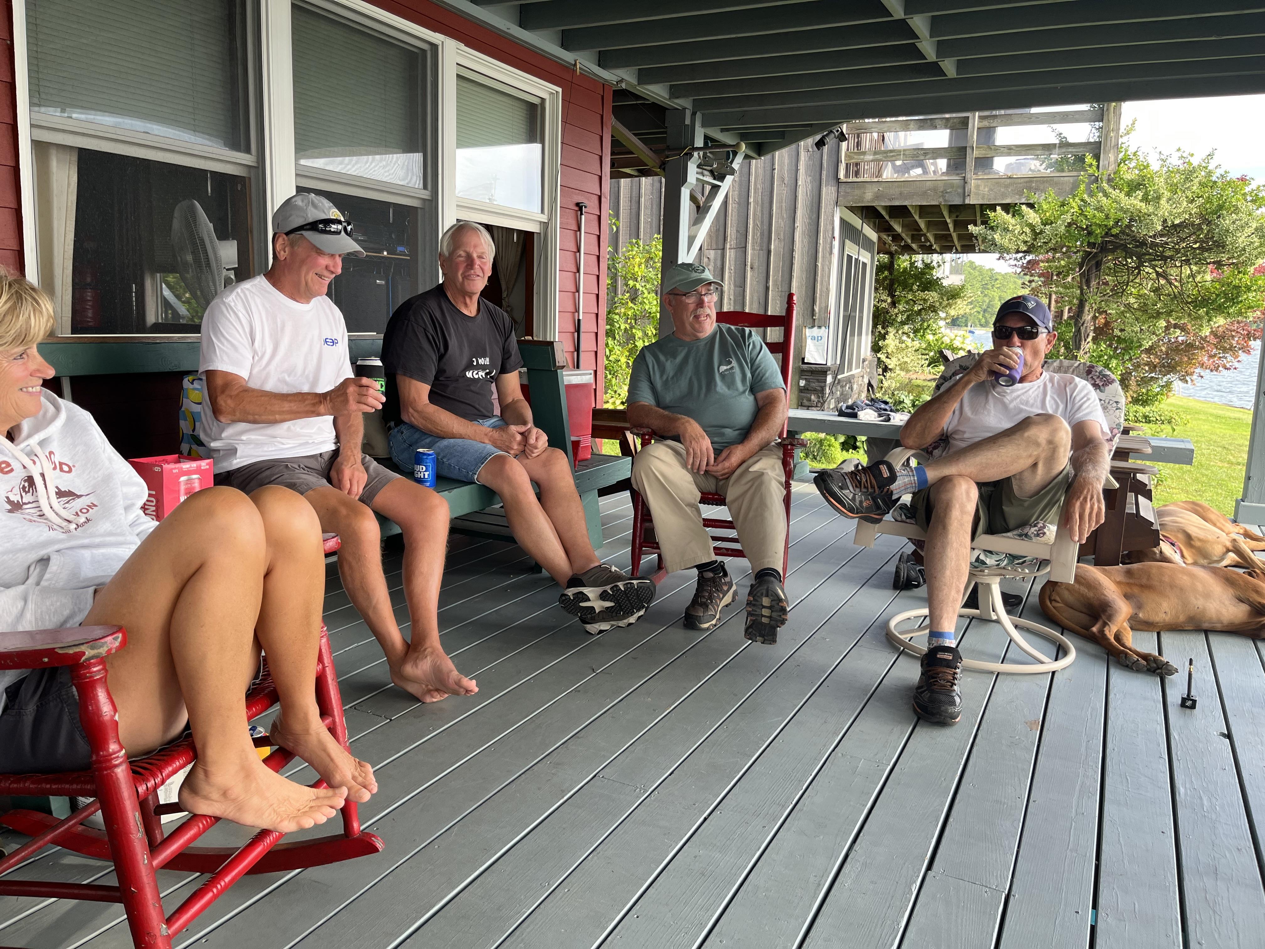 Group of friends gathers on a porch, sharing stories and laughter on a warm summer day.