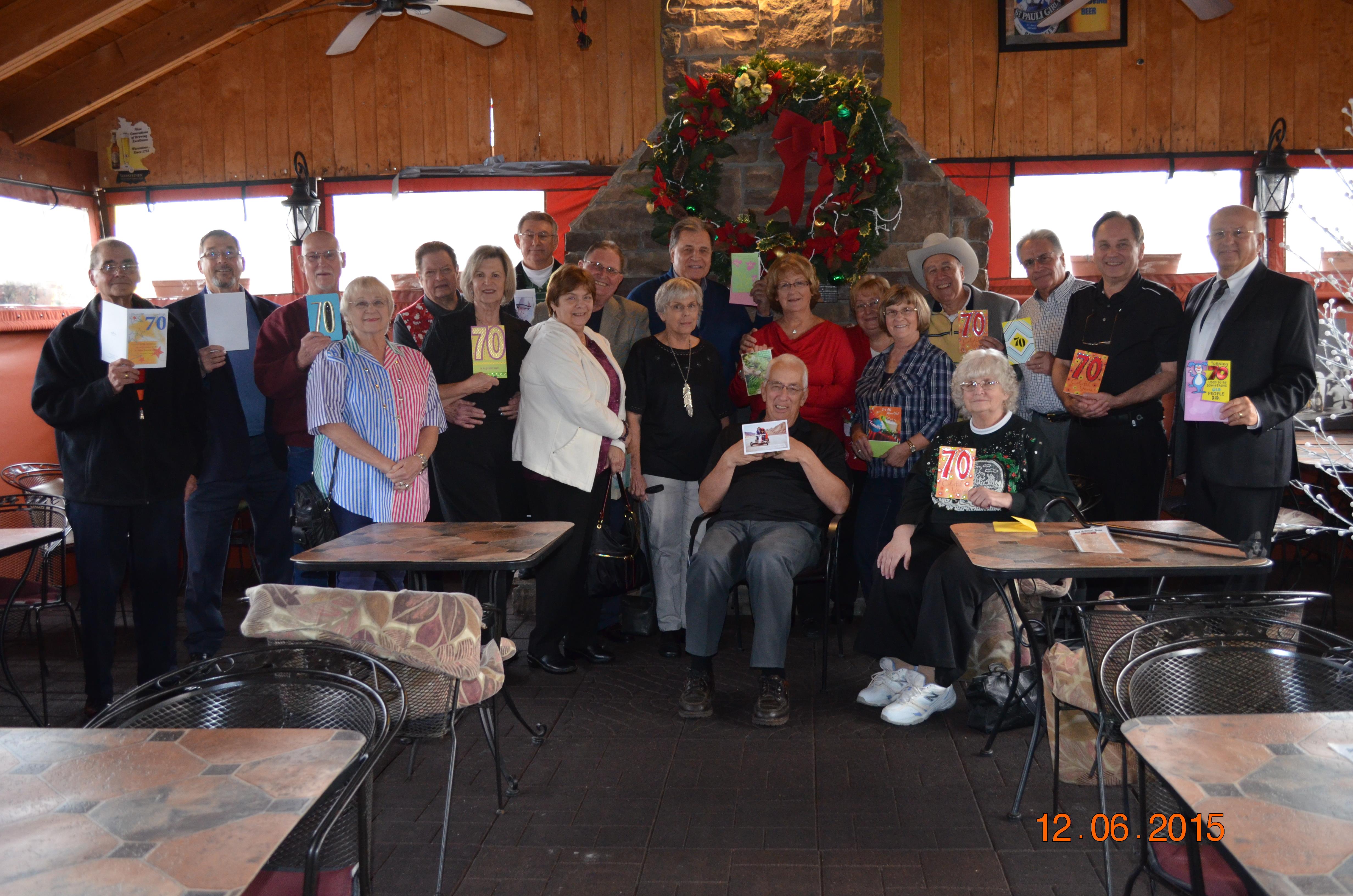 Friends gathered in a warm, rustic restaurant celebrating together with joyful expressions.