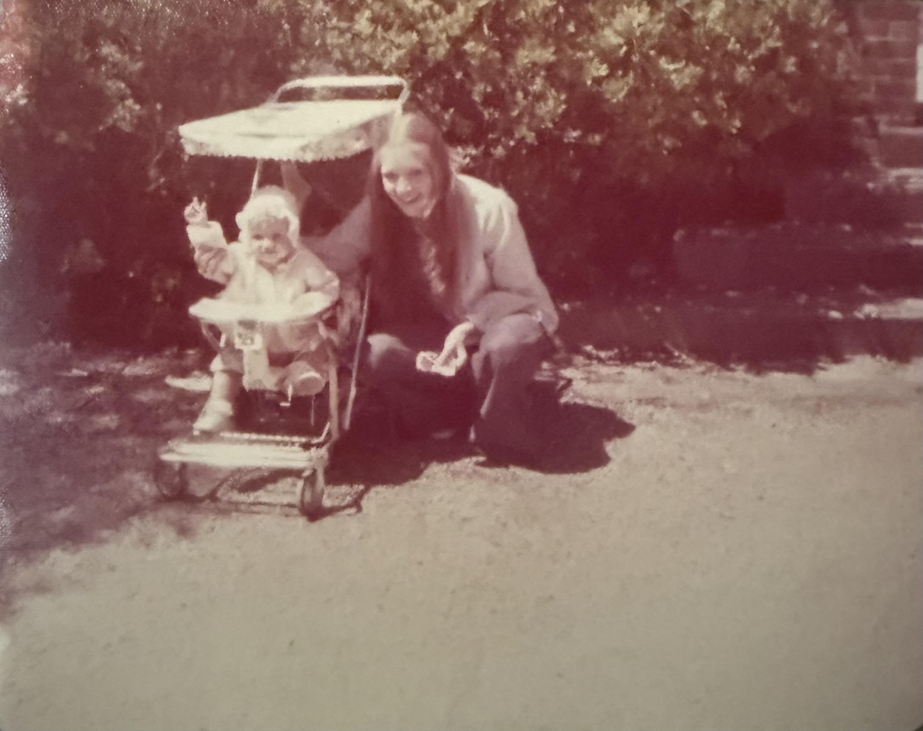A joyful moment shared as a child explores their stroller in a vibrant park setting.