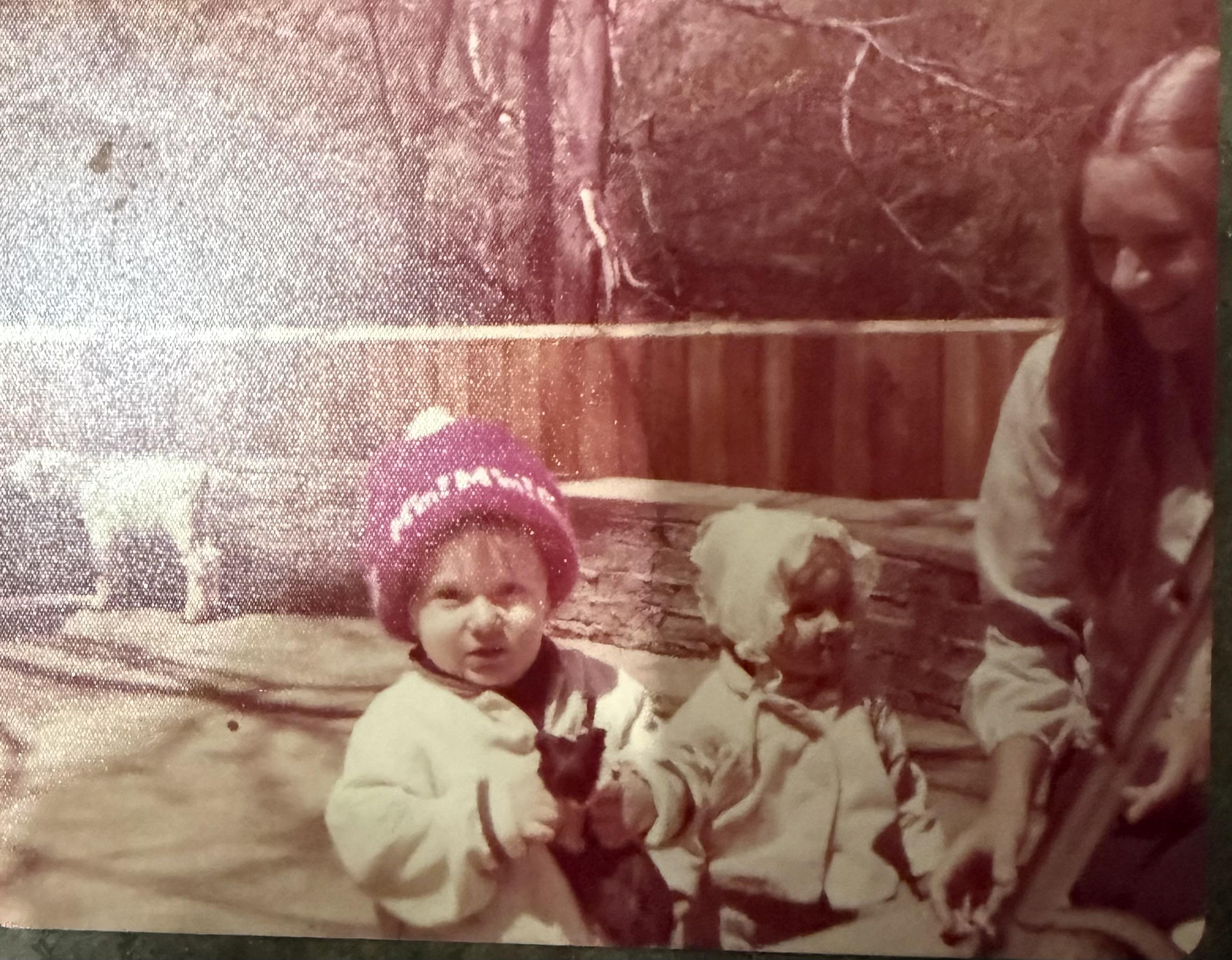 Two kids and an adult enjoy time outdoors, smiling in the vibrant sunlight and nature.