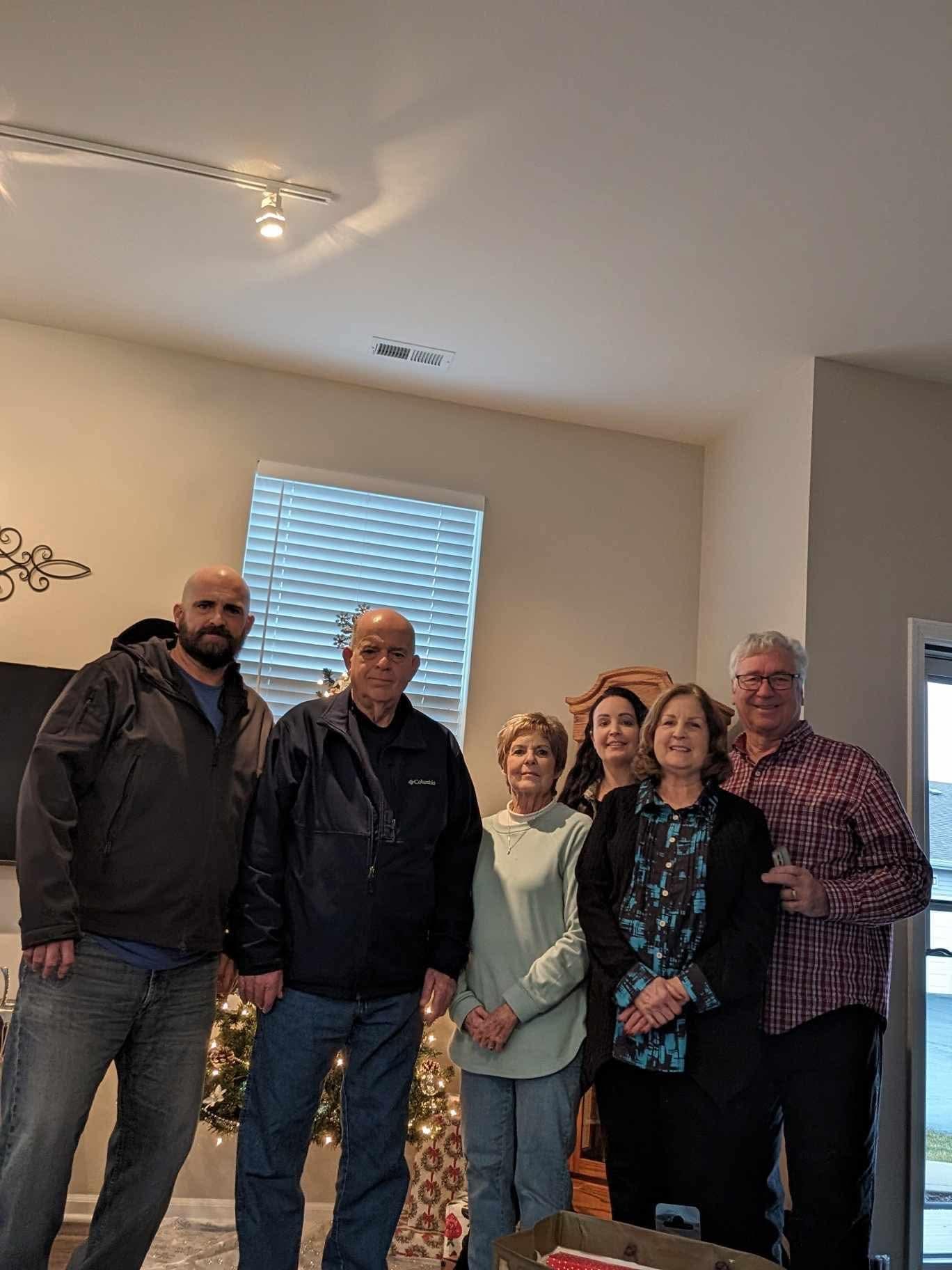 Friends smile as they gather in a cozy living room for a joyful reunion.
