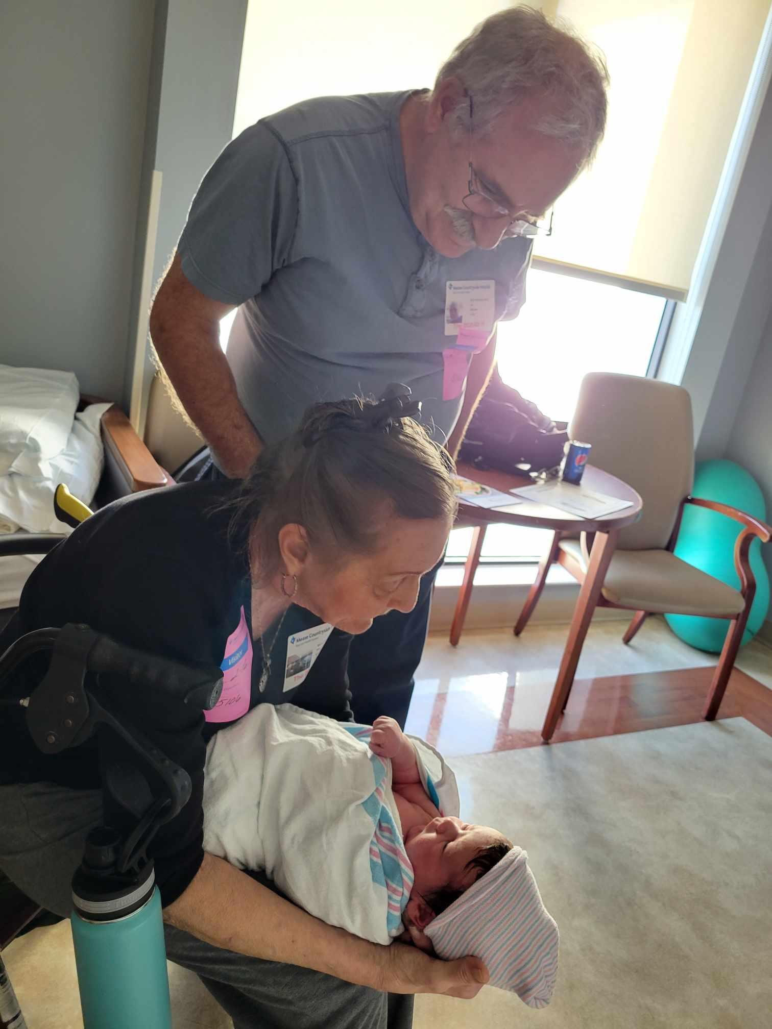 Family members gather to welcome a newborn in a warm hospital setting filled with joy.