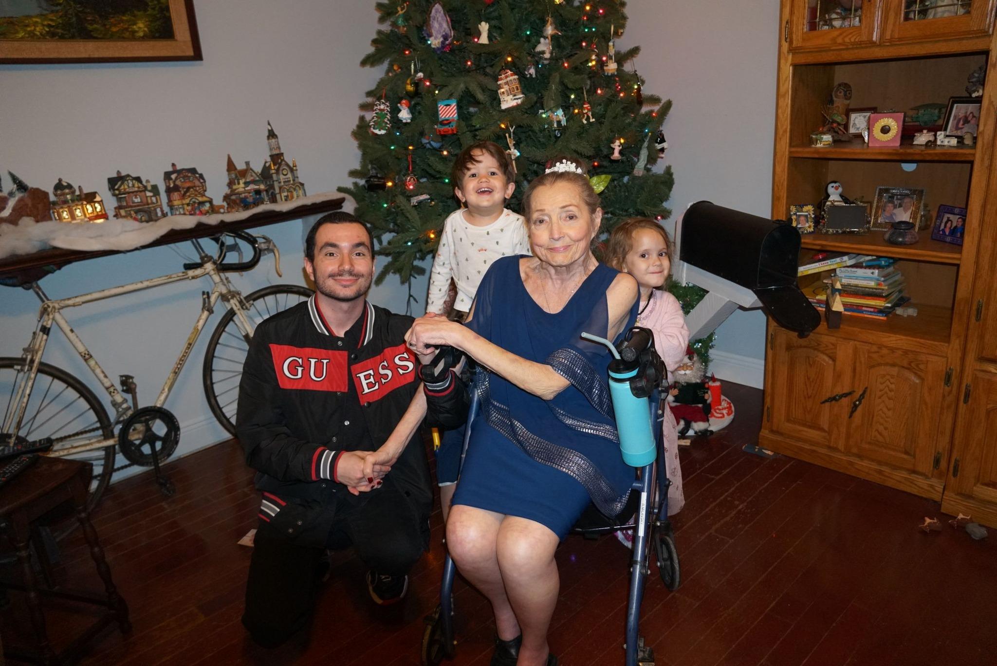 People enjoy a joyful moment near a decorated Christmas tree at home.