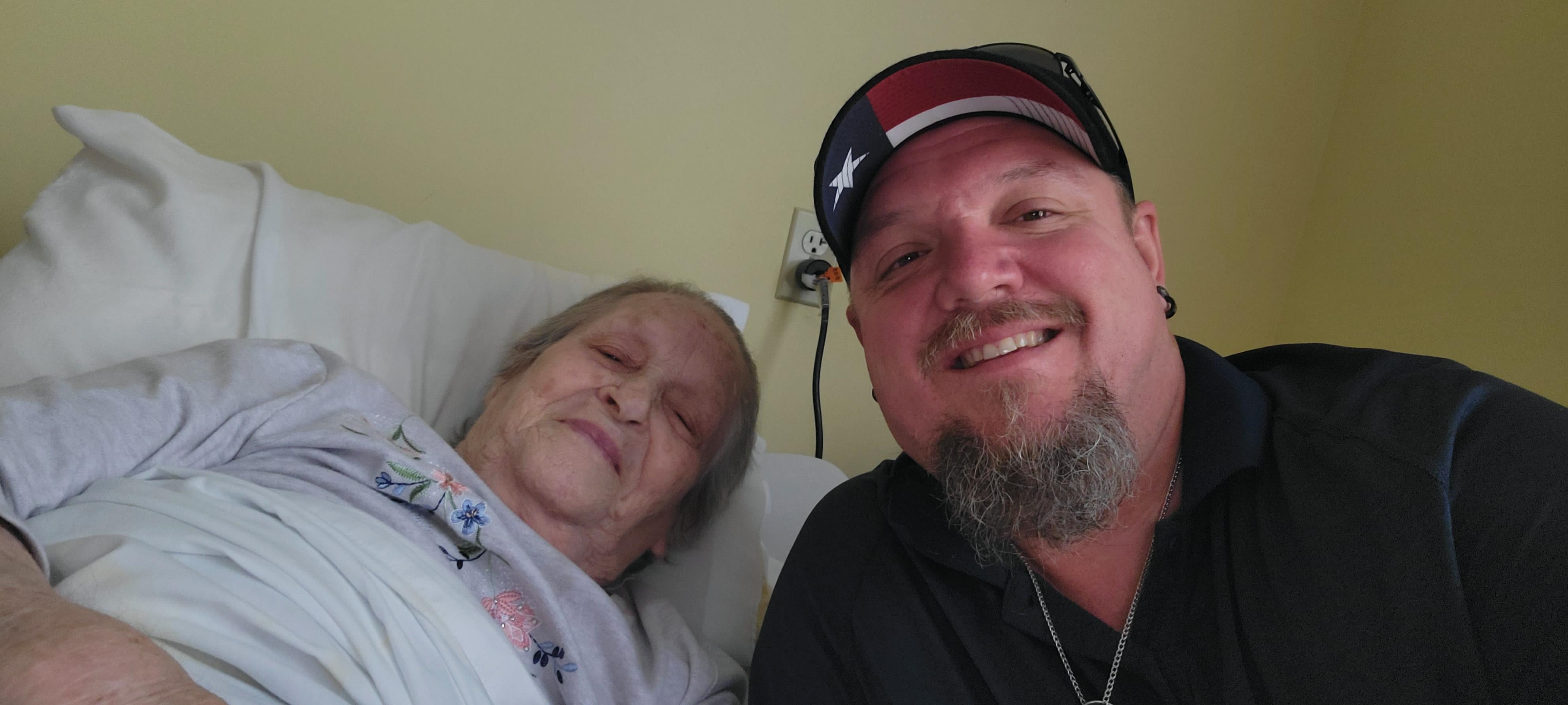 A man poses happily with a patient in a health facility's room, capturing a moment of connection.
