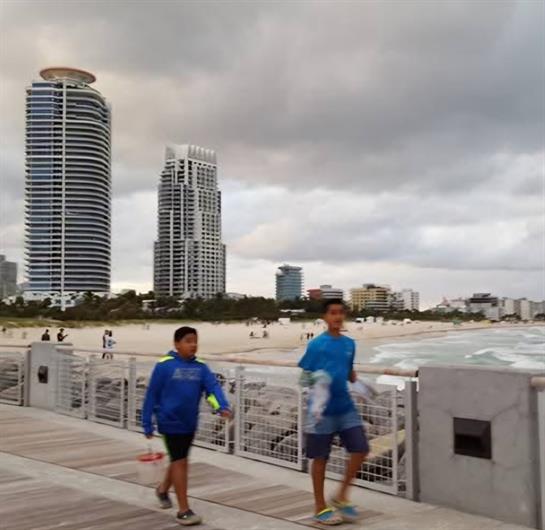 A group of people walking on a boardwalk