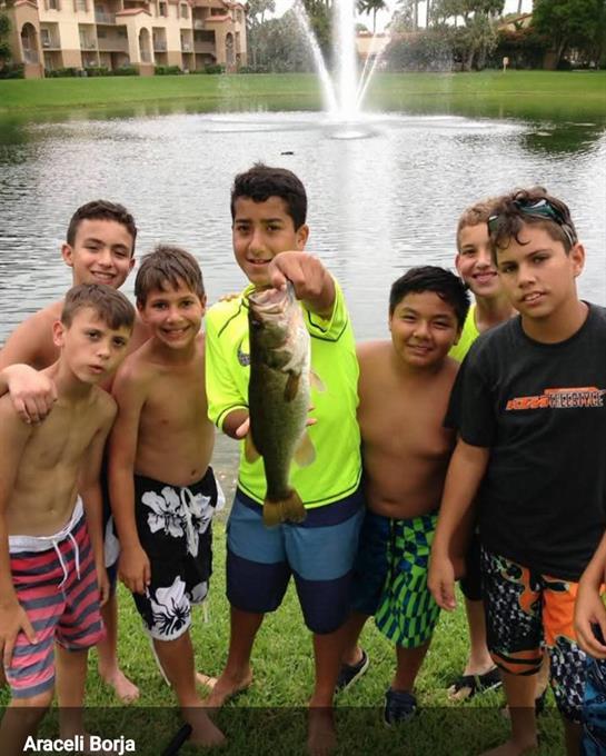 A group of boys posing for a picture with a fish