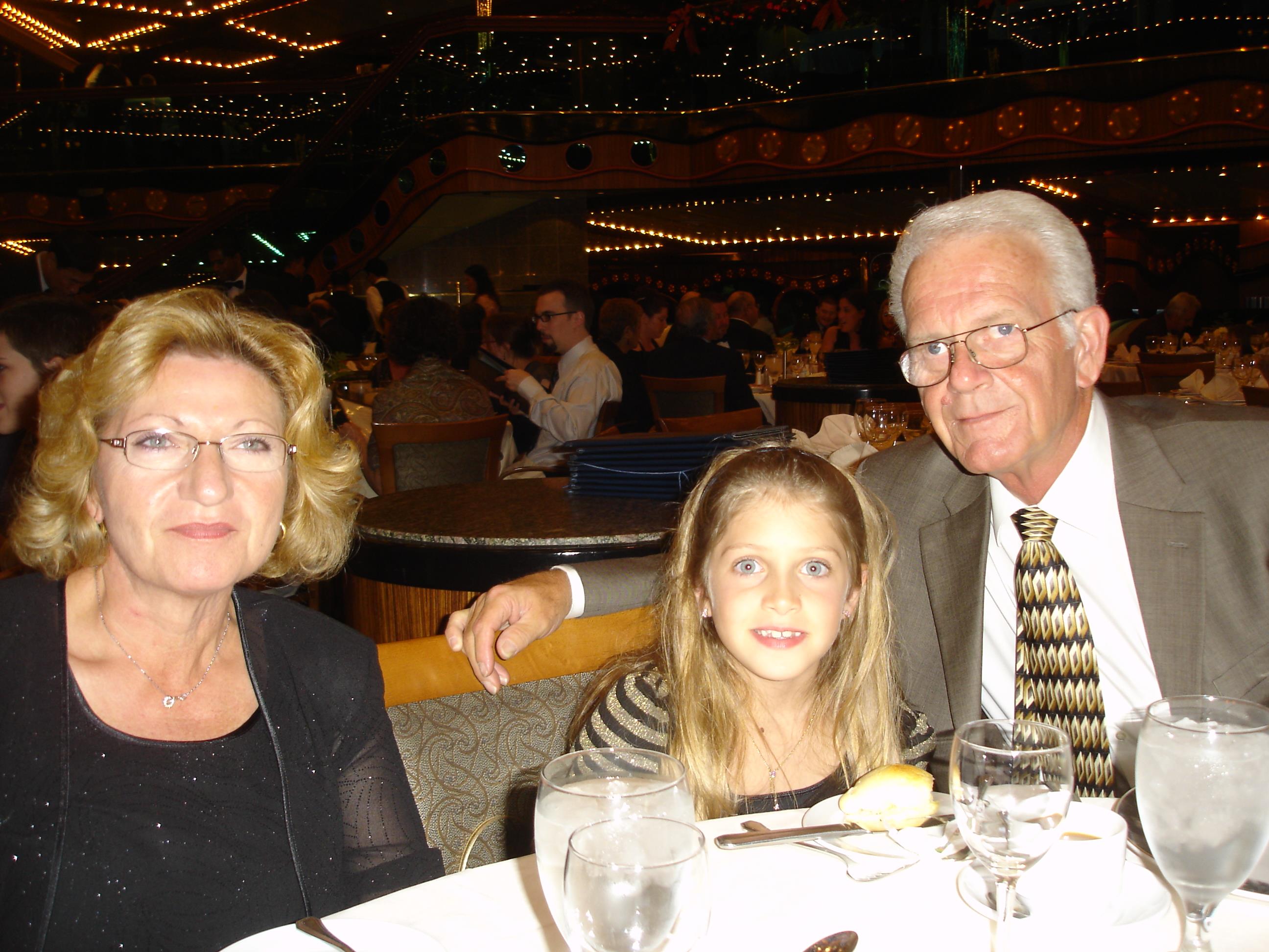 A family enjoys dinner together in a warmly lit restaurant with festive decorations.
