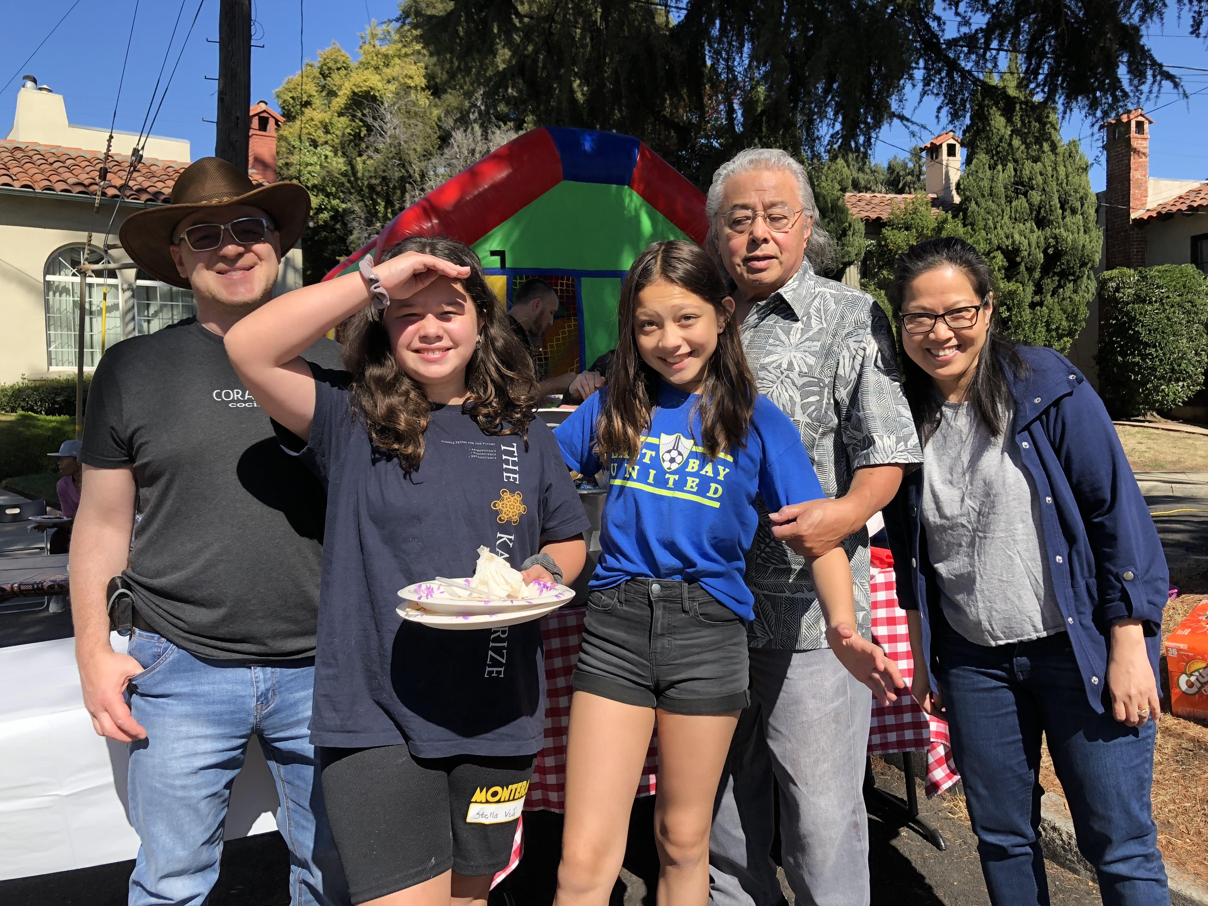 Friends and family enjoy food and laughter at a community gathering in California on a sunny day.