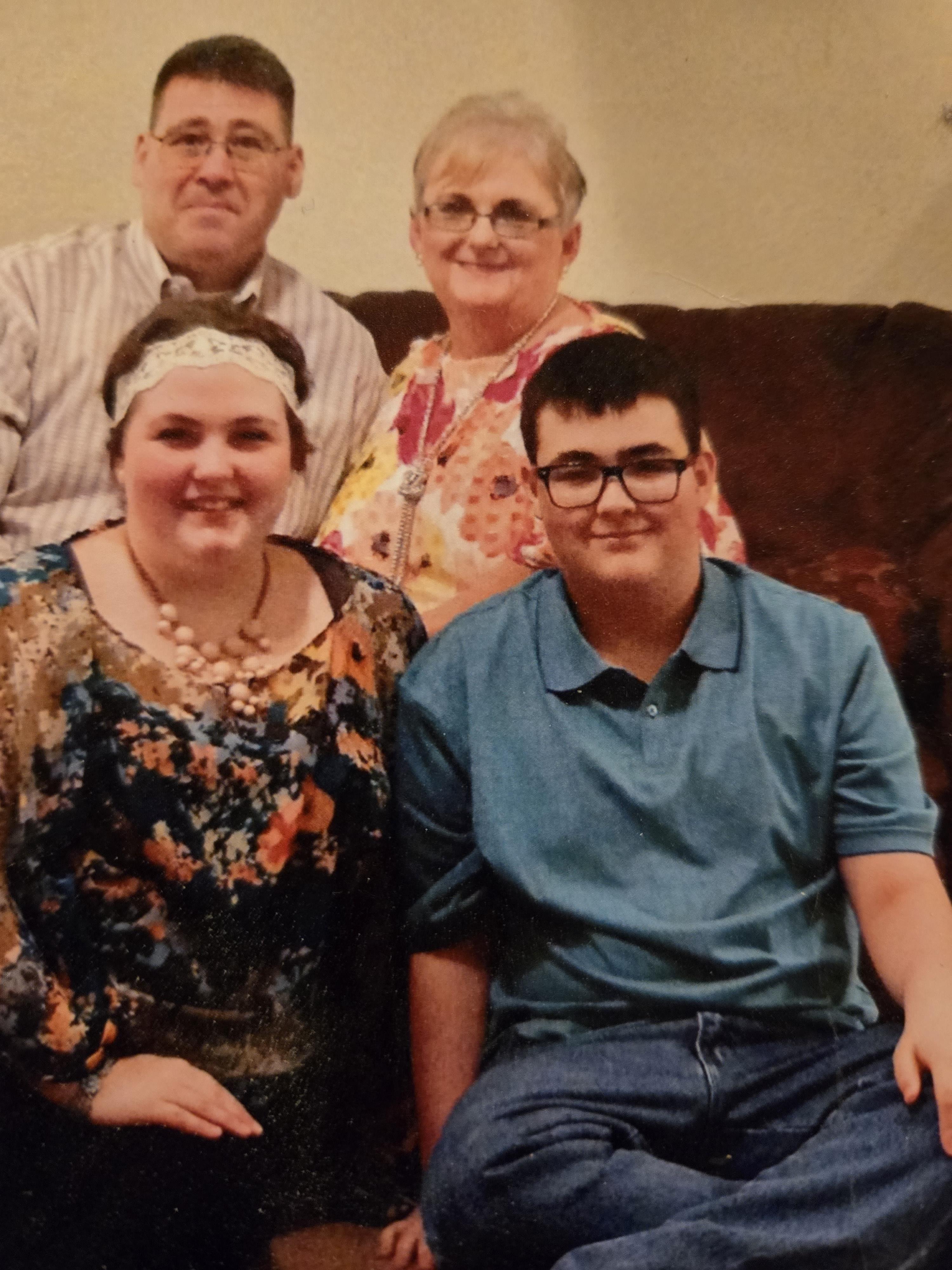 Four family members happily pose in a cozy living room, showcasing their love and connection.