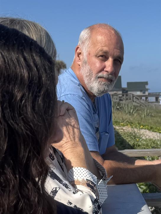 A man with a beard sitting on a bench