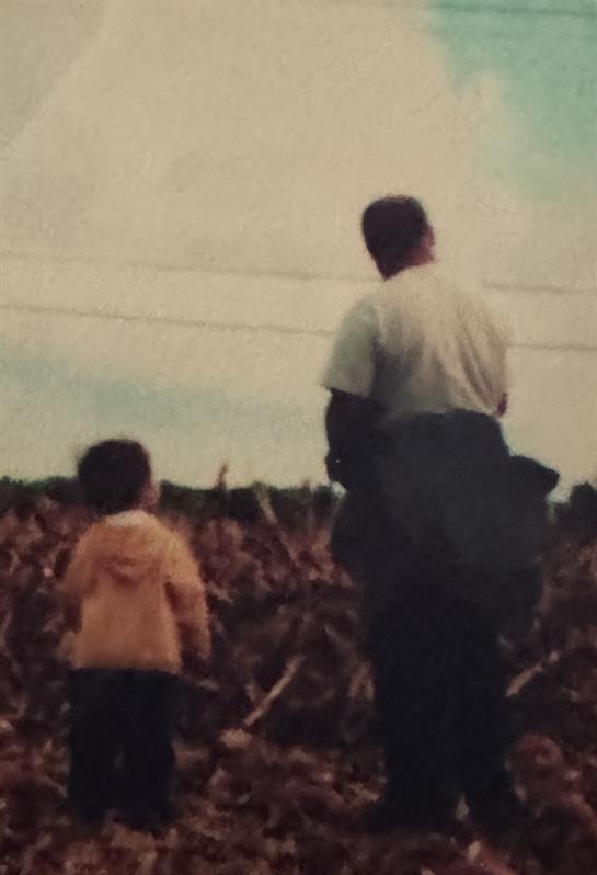 A man and child walking in a field