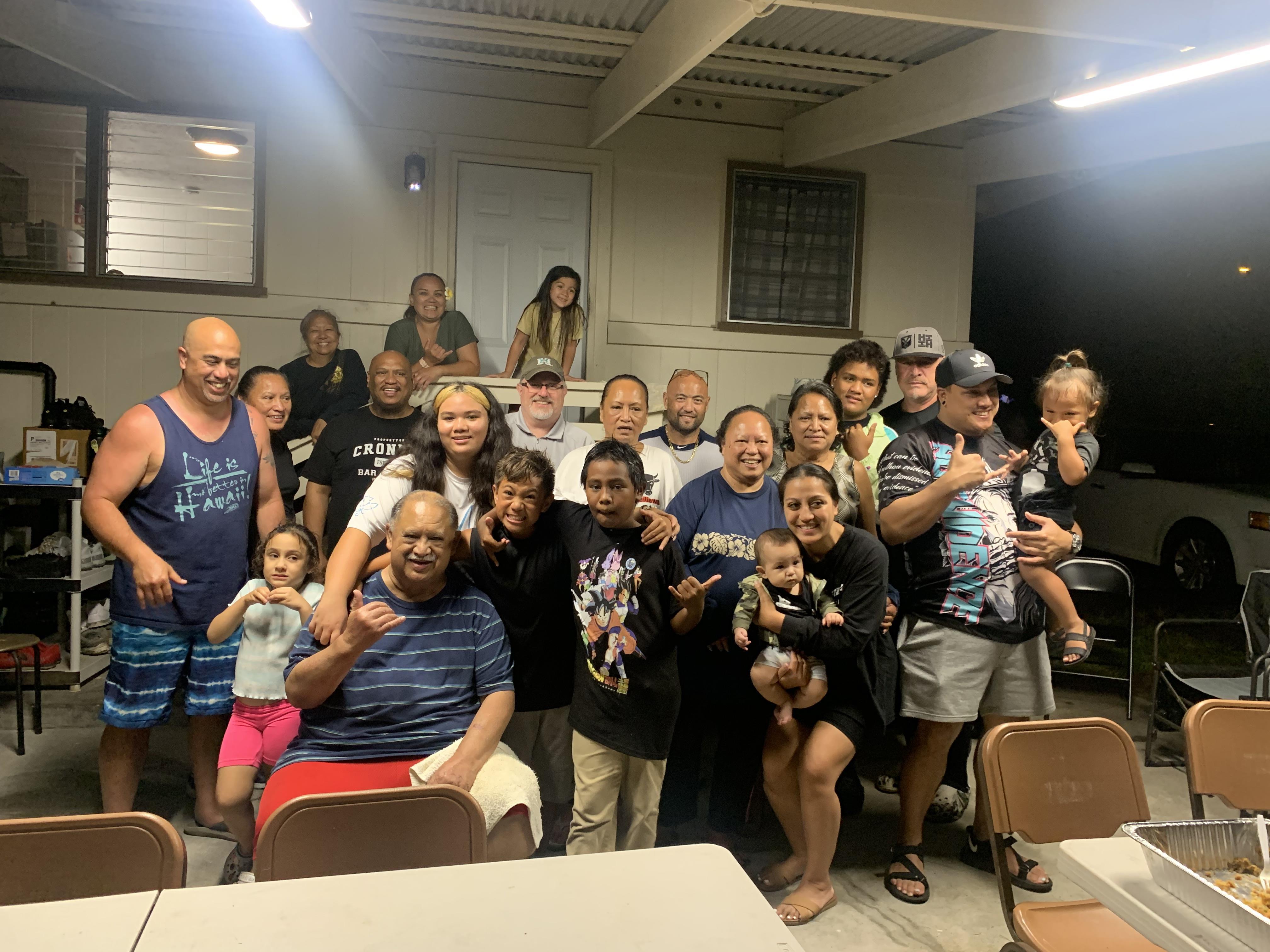 A large family enjoys a joyful reunion in an outdoor space filled with laughter and conversation.