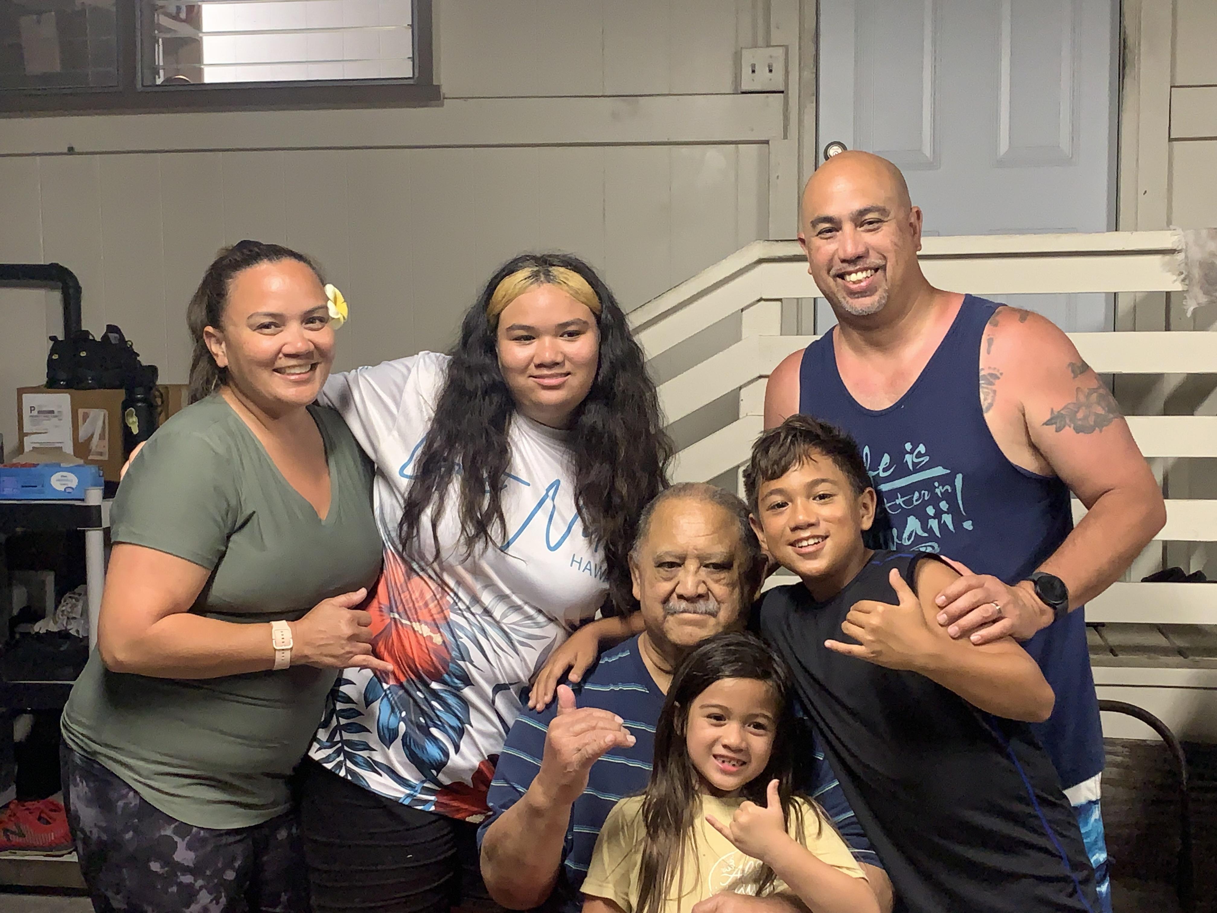 Family members celebrate together in a cozy Hawaiian home filled with joy and laughter.