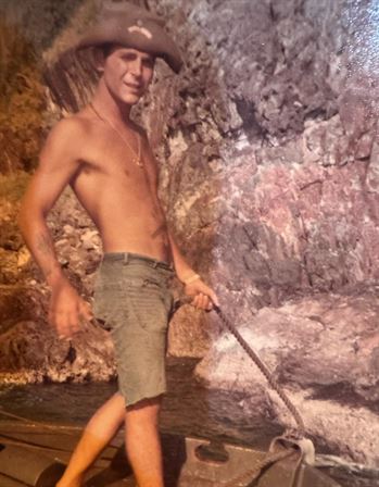 A man standing in water with a rope