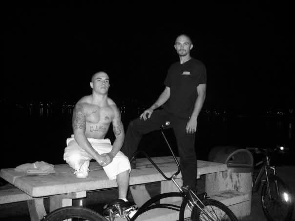 Two friends relax at night on a dock, enjoying each other's company with their bikes.