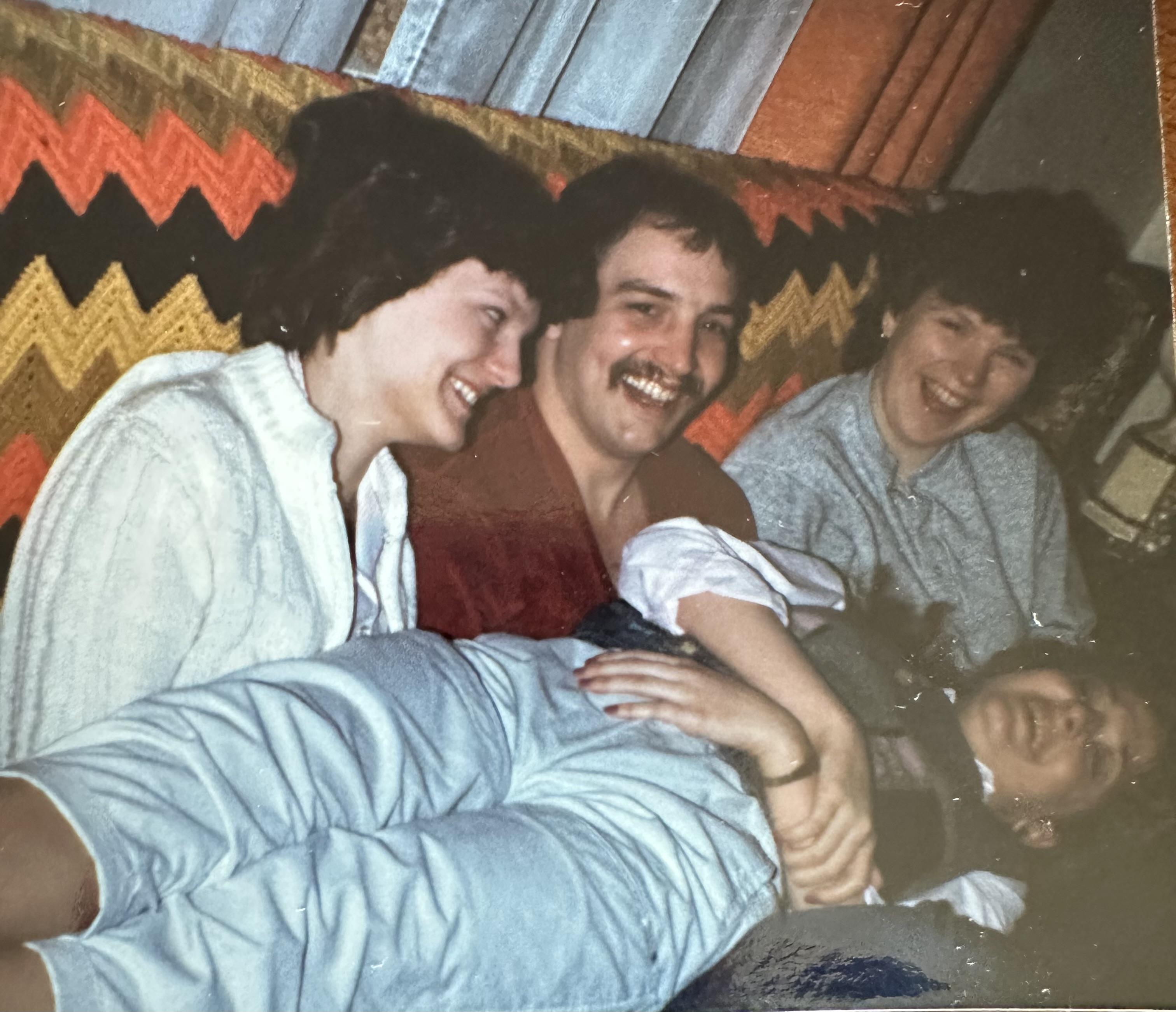 Group of friends share laughter and good times while relaxing in a decorative indoor setting.