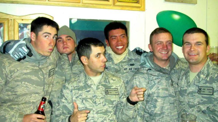 Soldiers share laughter and camaraderie at a military event held in the evening.