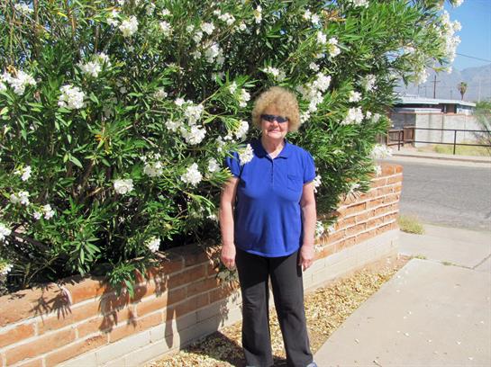 A woman standing in front of a bush