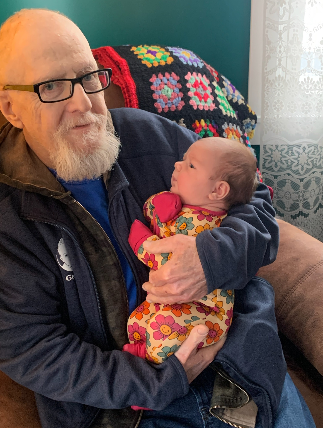 A joyful moment where a grandfather cradles his grandchild in a vibrant home setting.