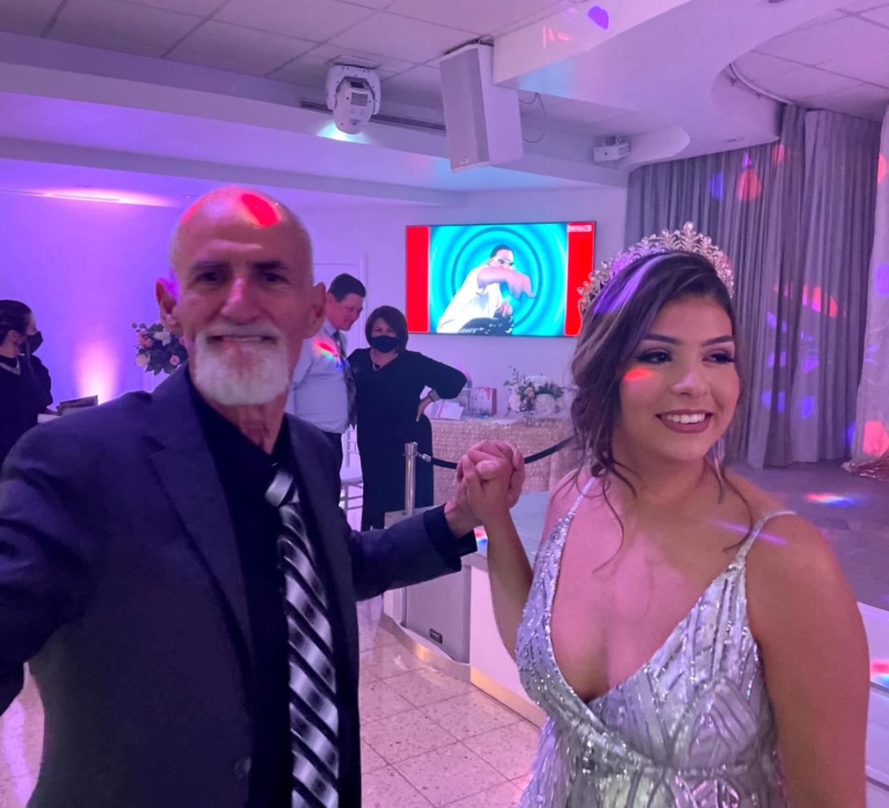 Guests dance and celebrate together in a stylish venue filled with vibrant decor and lighting.