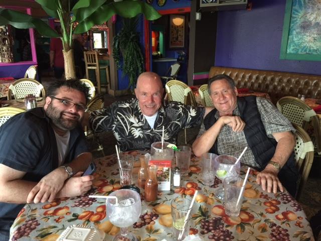 Friends enjoy drinks and laughter at a vibrant table in a lively restaurant.