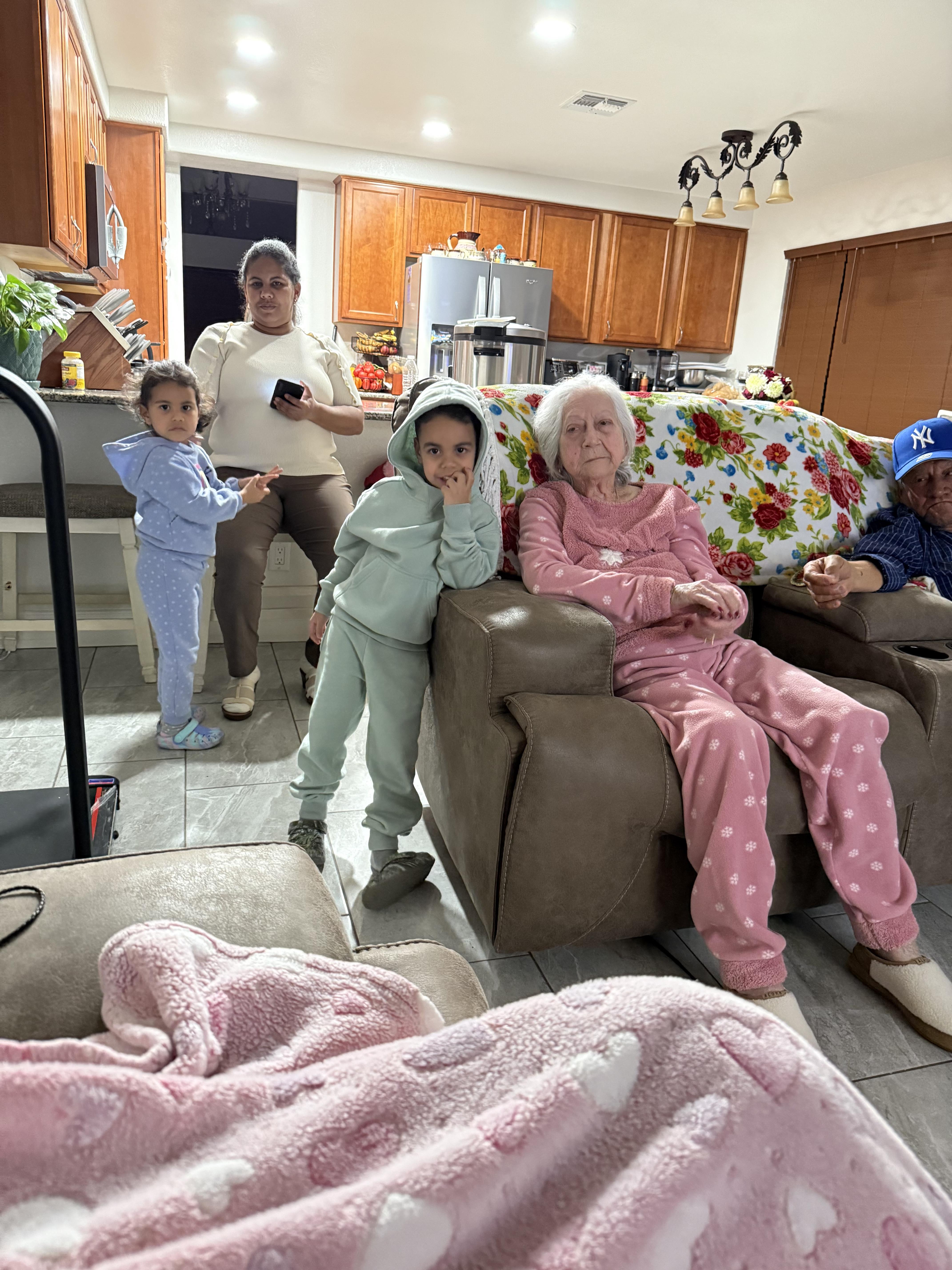 Family members enjoy a relaxed evening together in their living room, sharing smiles and laughter.