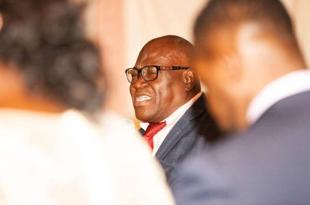 A distinguished speaker addresses guests at a formal gathering, displaying passion and engagement.