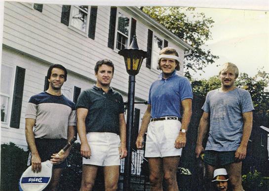 A group of men standing in front of a house