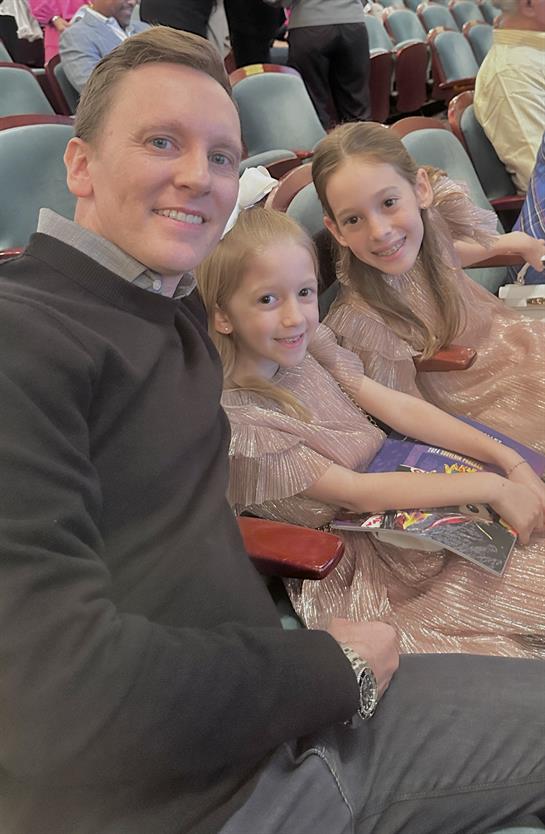 A man and two girls sitting in chairs