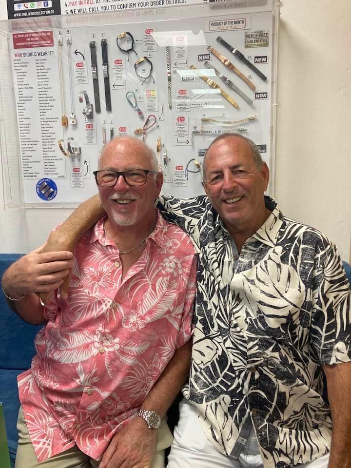 Two friends share a joyful moment while wearing colorful shirts at a gathering.