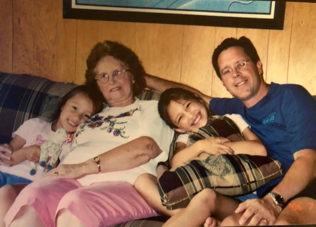 Family members share a comfortable moment together, relaxing on a couch with smiles.