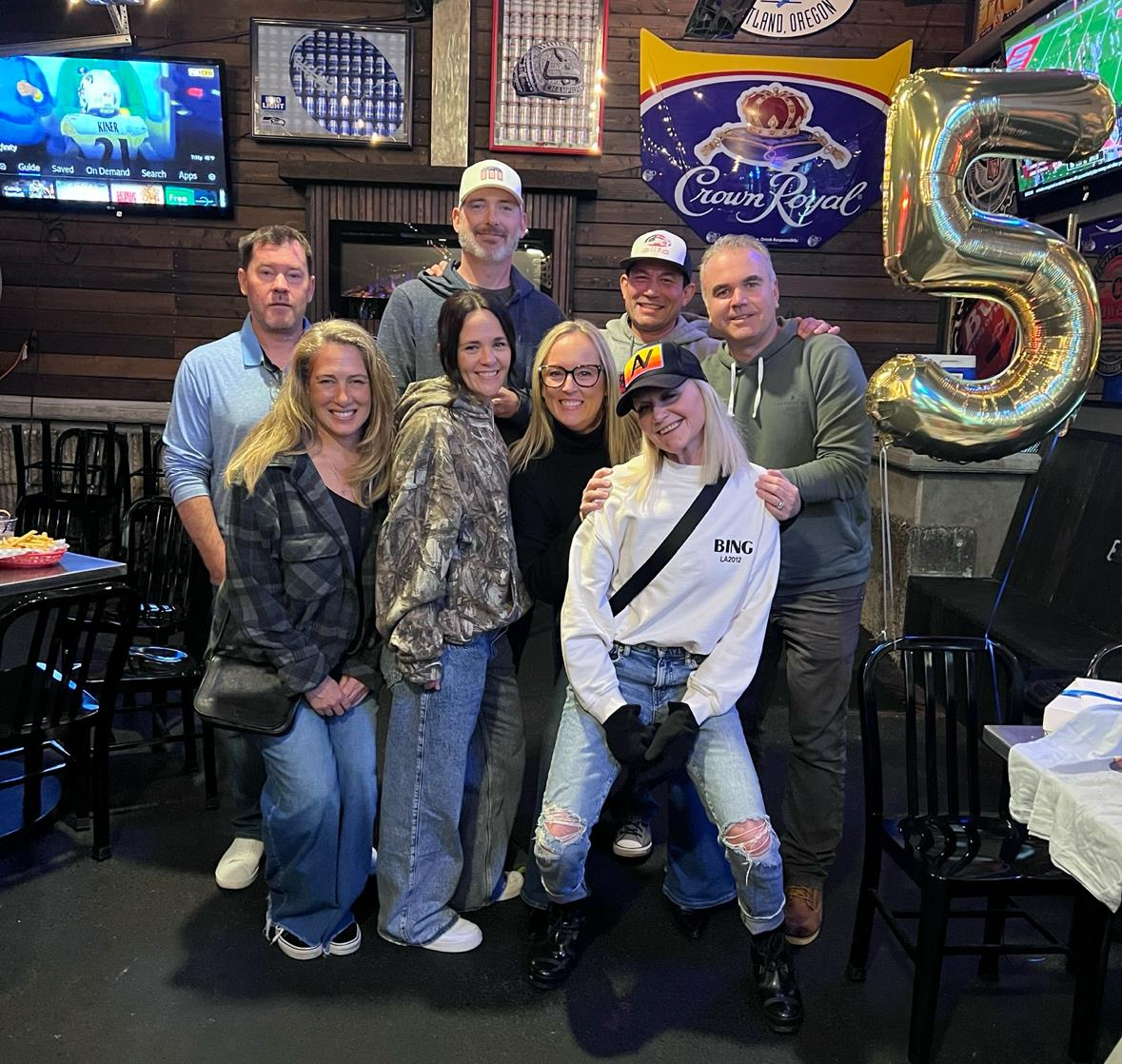 Friends gather at a bar to celebrate a milestone birthday, enjoying drinks and laughter together.