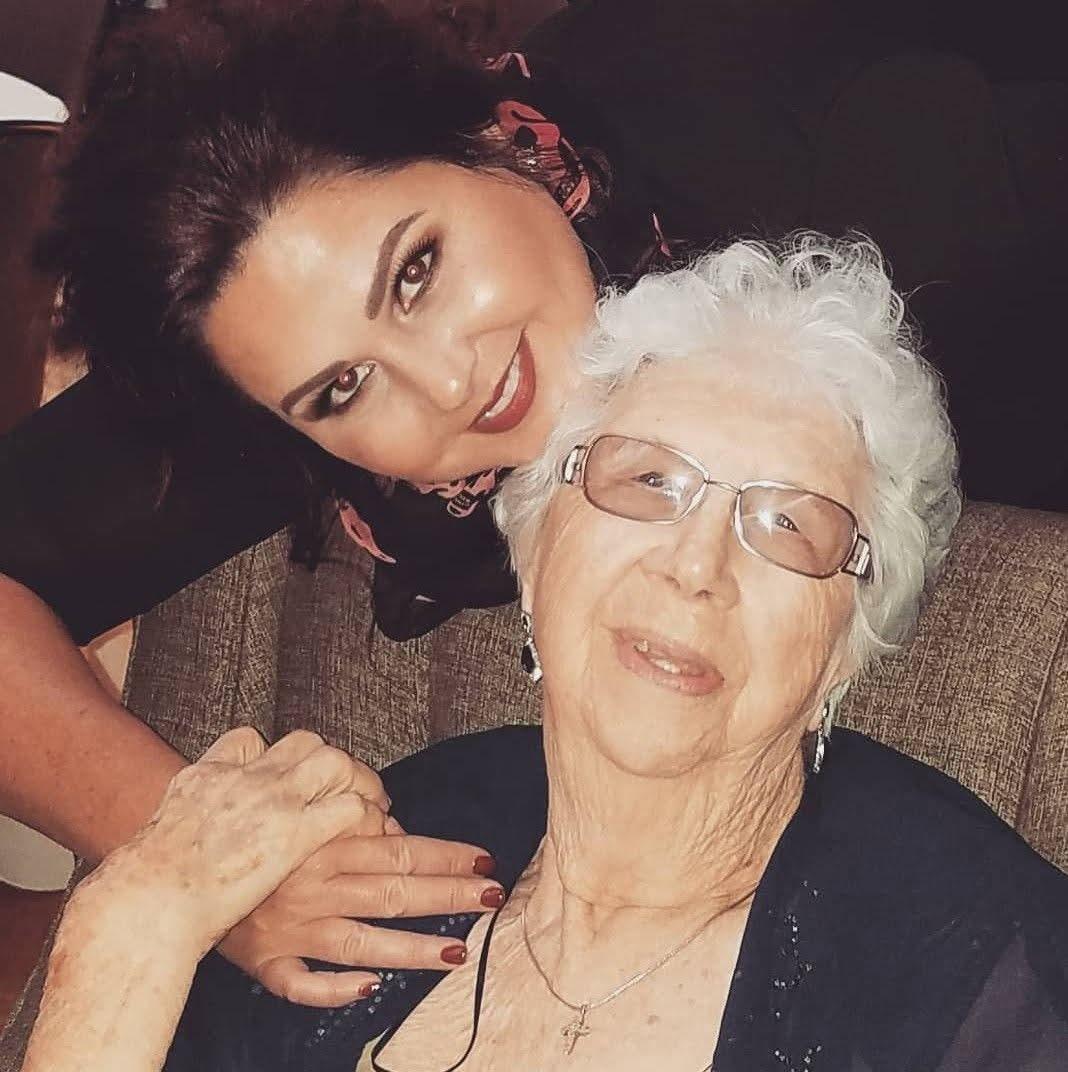 Grandmother and granddaughter share a warm embrace during a family gathering at home.