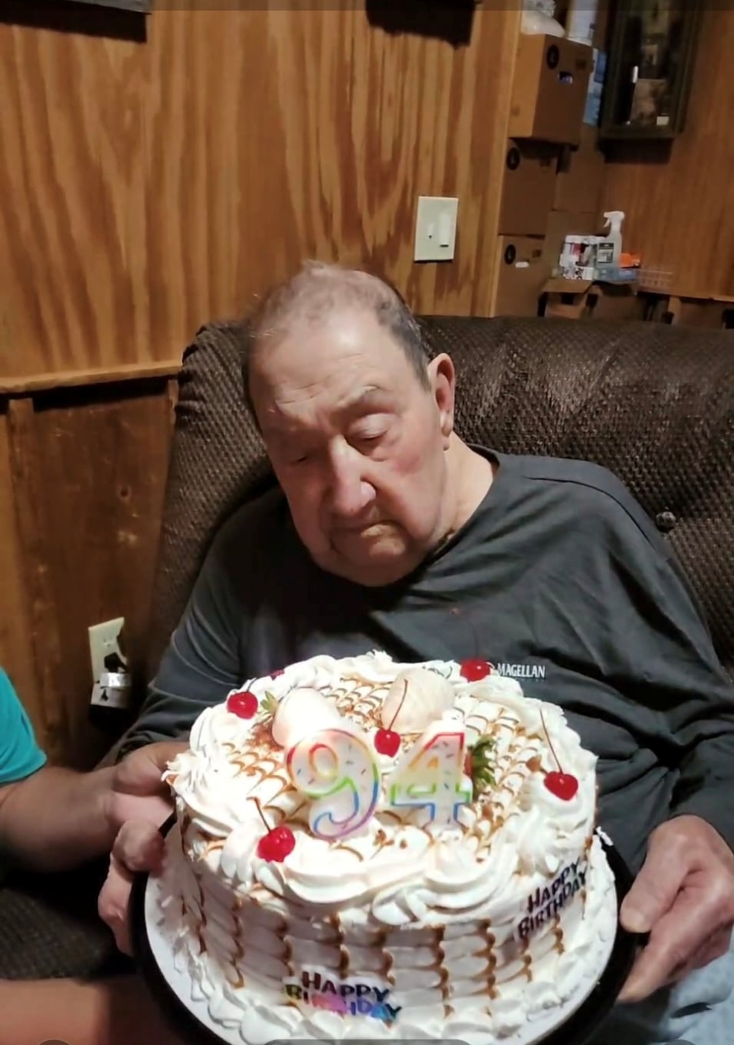 A man sitting in a chair holding a cake