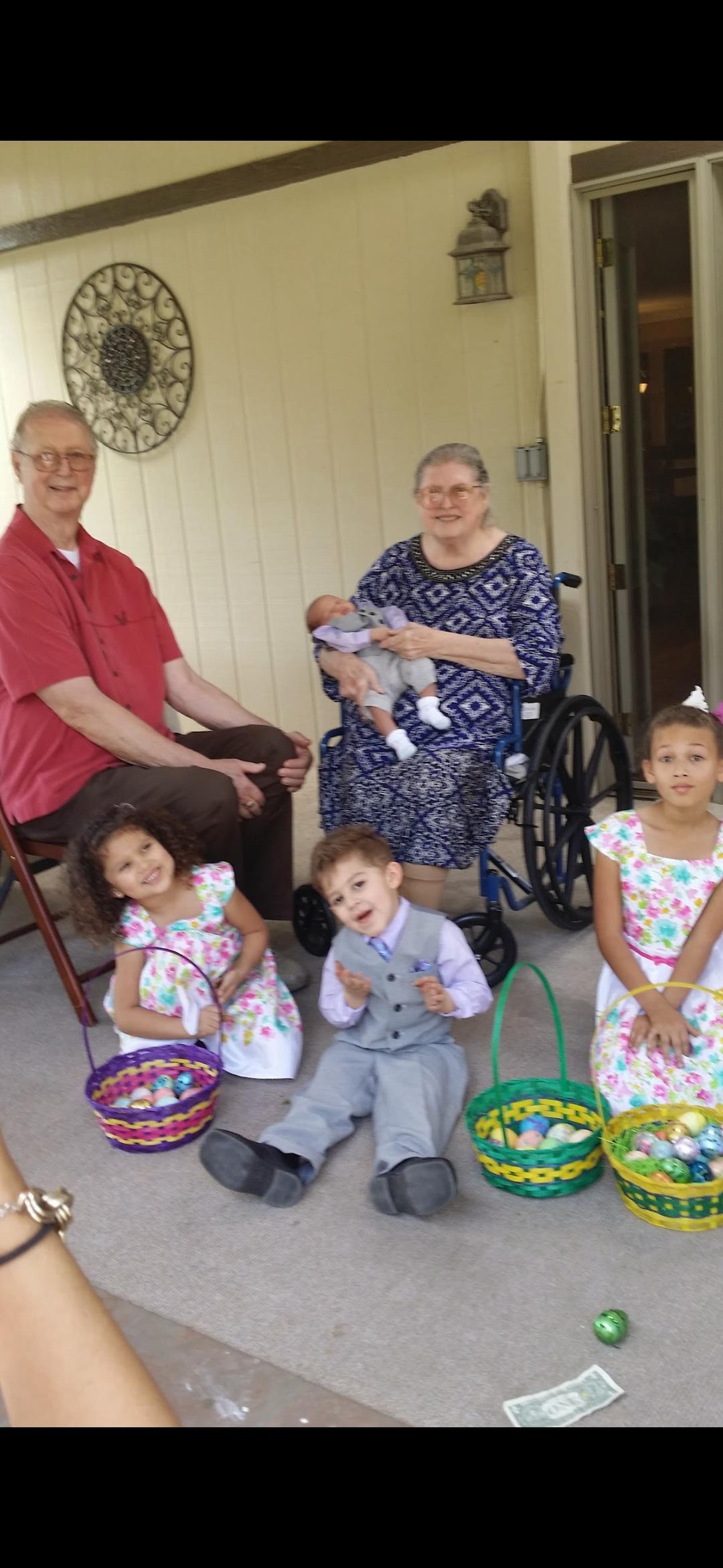 Family members happily gather outside in colorful dresses and baskets in a warm setting.