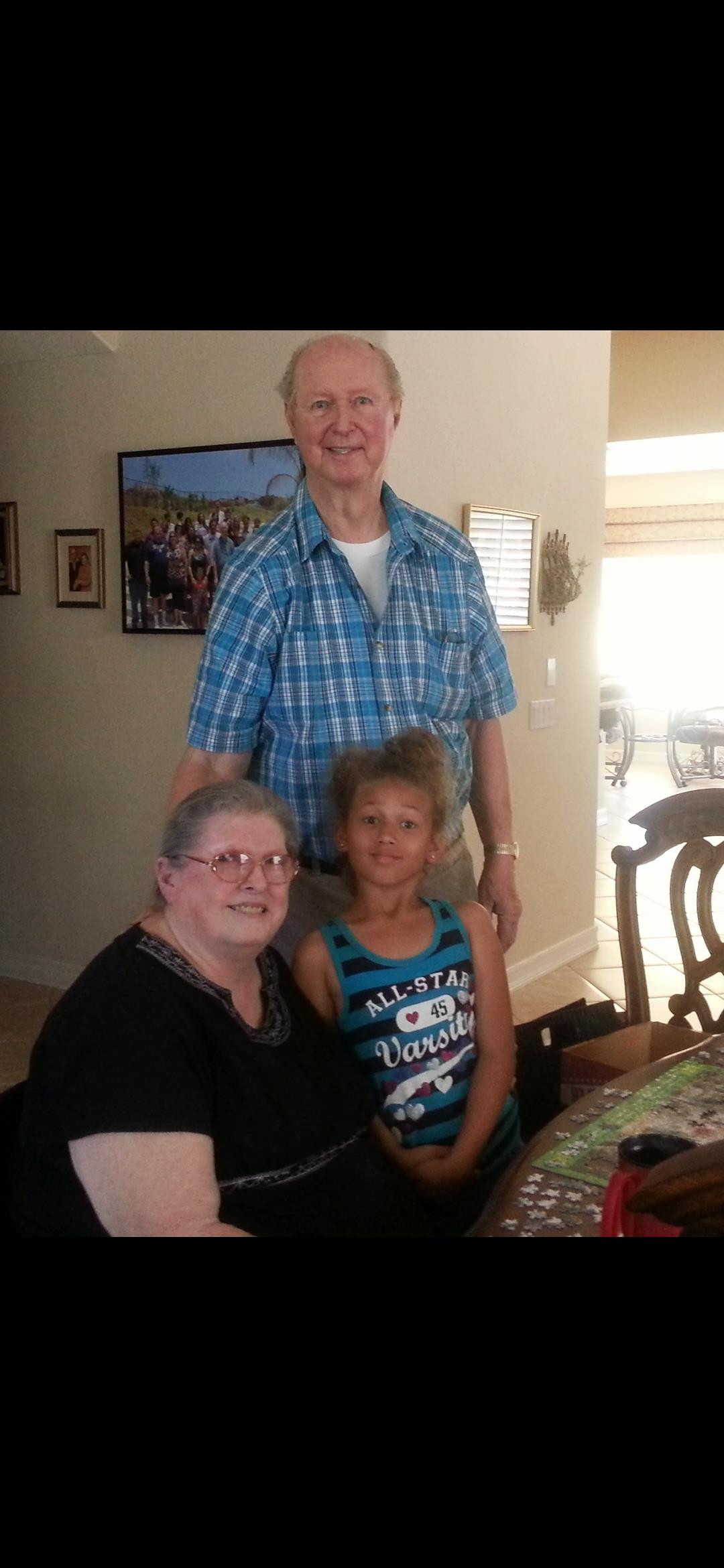 Three family members enjoy a warm moment together in a bright living room setting.