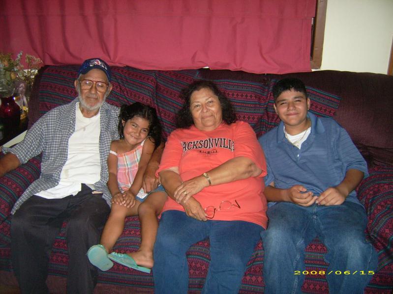 Family members relax together on a couch, sharing smiles and laughter in a warm home atmosphere.