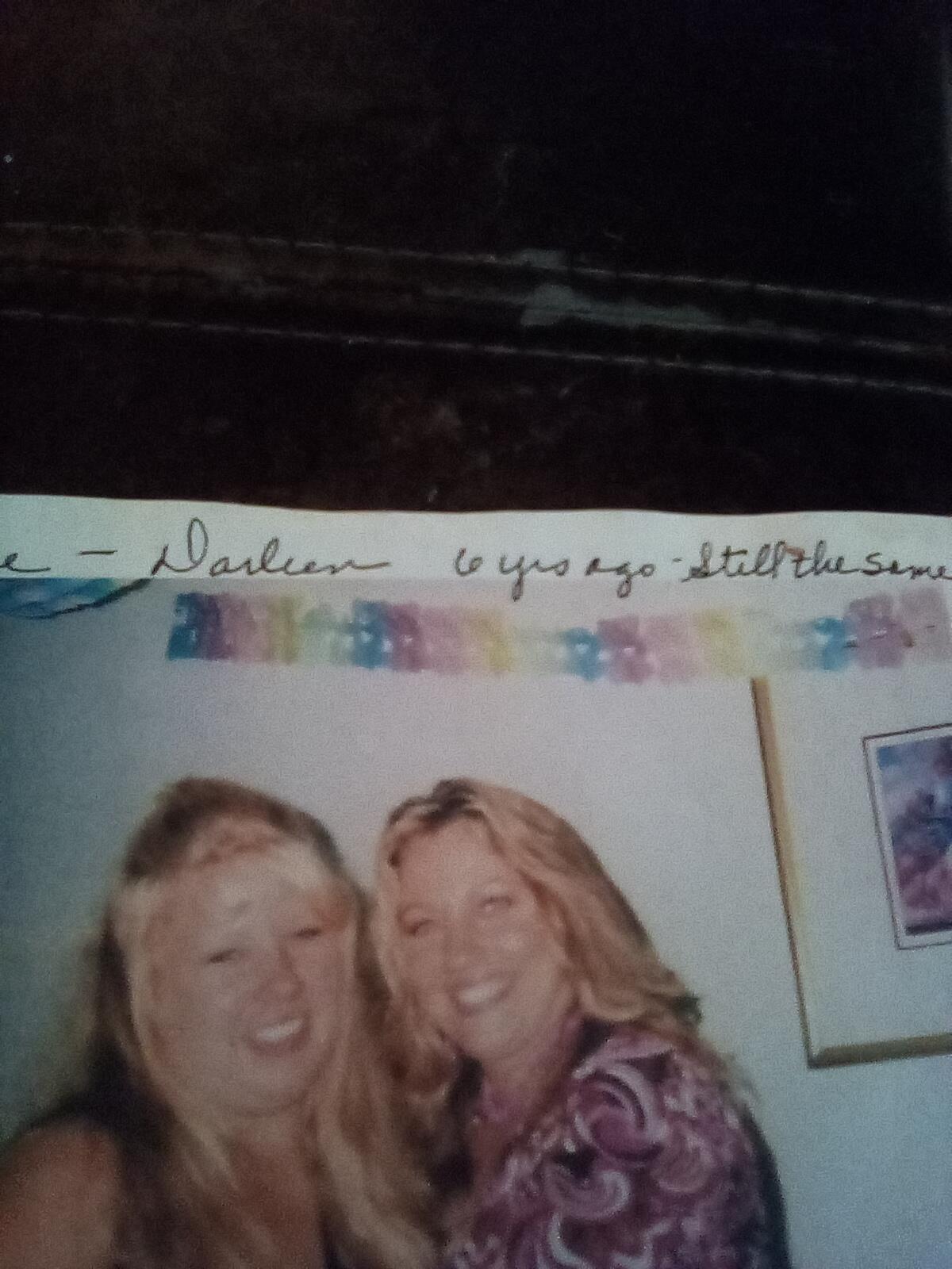 Two women are enjoying each other's company at a festive gathering, smiling warmly.