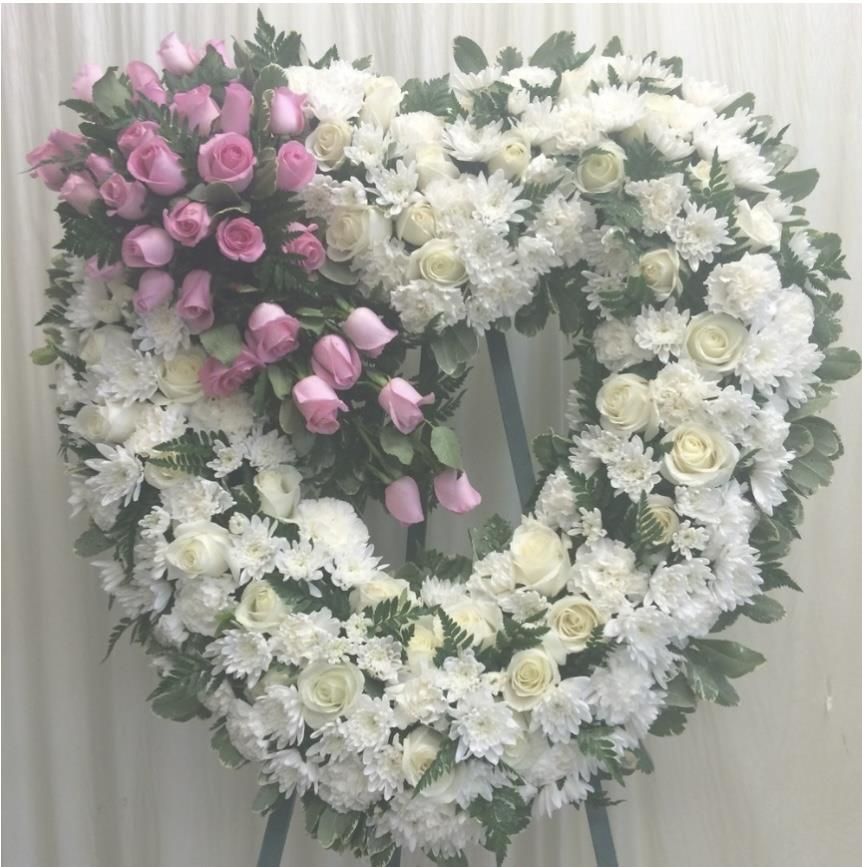A beautiful heart-shaped floral display with white roses and pink blooms, perfect for celebrations.