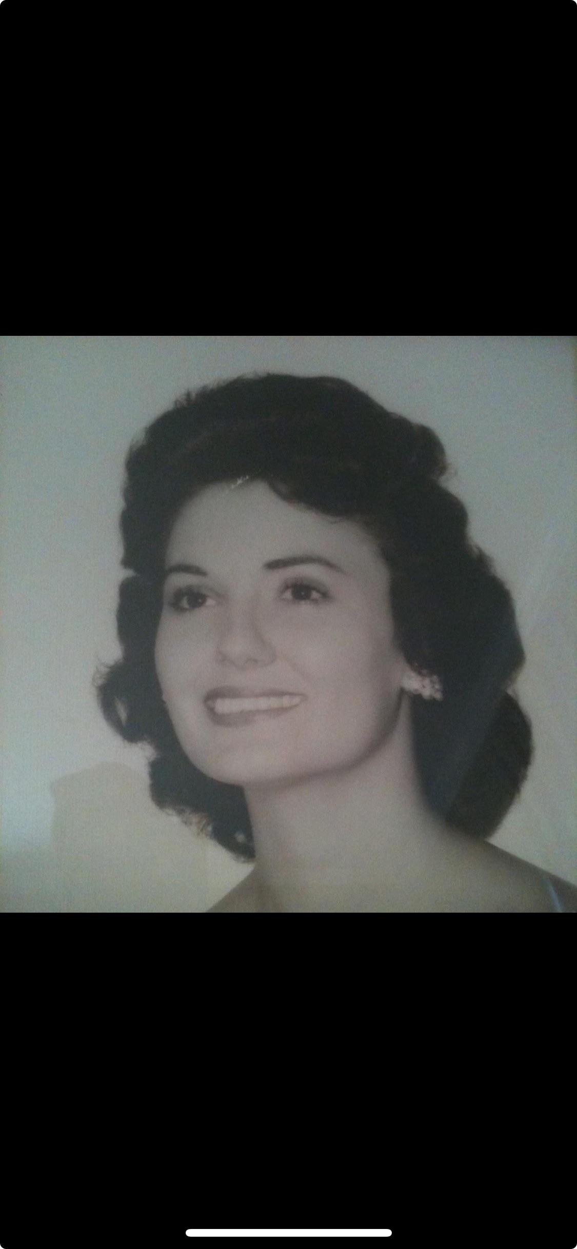 A woman with a vintage hairstyle beams, exuding grace and timeless beauty.